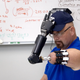 Jonny Matheny putting on a hat with a mind-controlled arm developed by DARPA. Image: Freethink